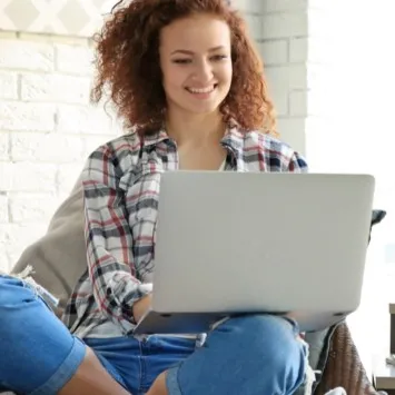 Happy lady looking into laptop | Floorco Premium